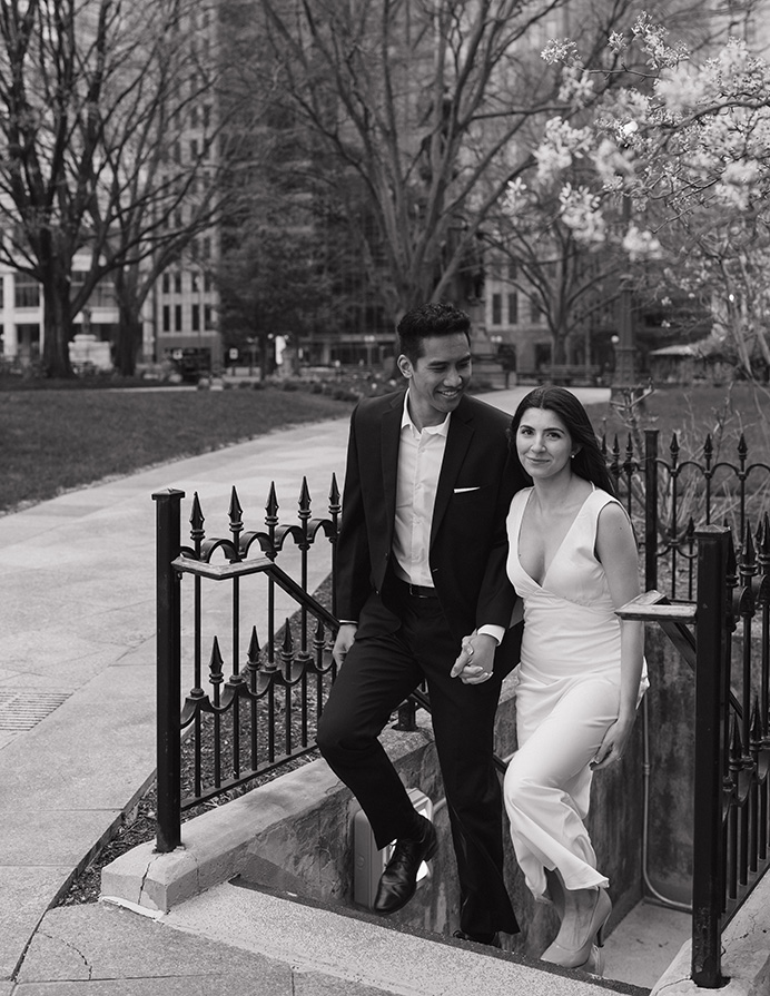 A newly engaged couple walks up a set of stairs near the Columbus Ohio Statehouse, enjoying a sunny day together.