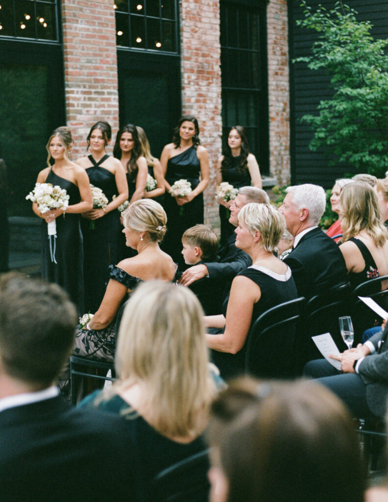 Black-tie wedding ceremony moment with The Walkers standing under tall indoor columns at The Ellis in downtown Columbus, OH.