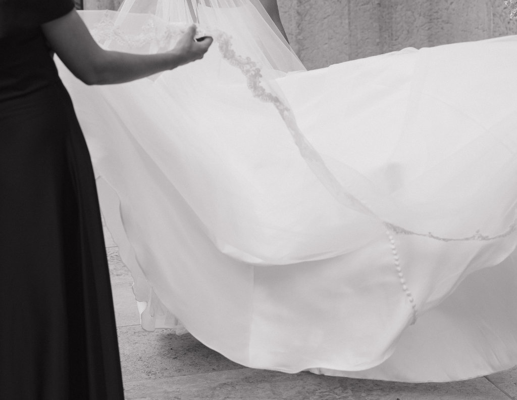 Flowing bridal veil and gown laid across a chair inside The Ellis.