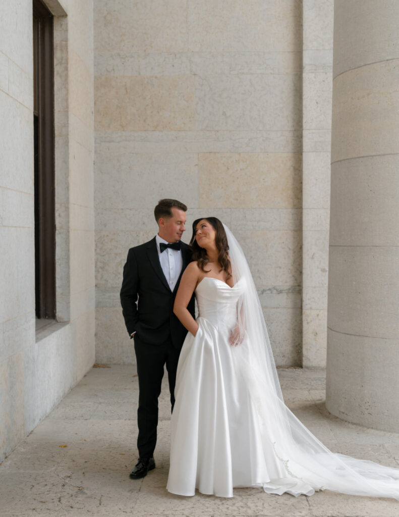 The Walkers posing arm-in-arm as newlyweds outside The Ellis in downtown Columbus.