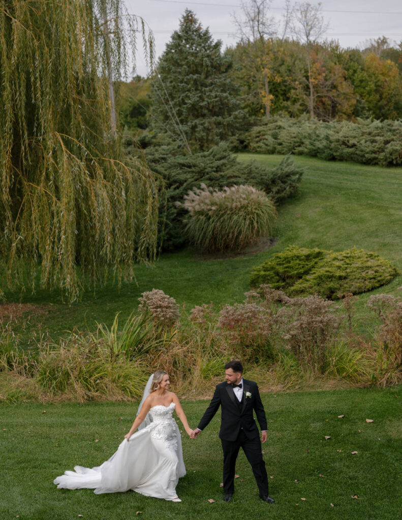 Bride and groom walking outdoors photographed in timeless film style.