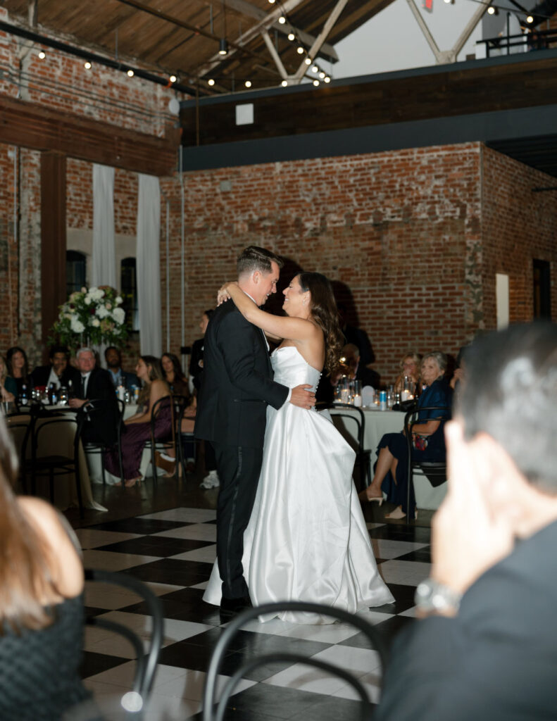 The Walkers sharing their first dance surrounded by guests inside The Ellis.