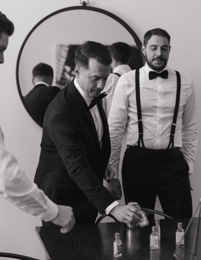 Groom and groomsmen getting ready inside the groom’s suite with natural light.