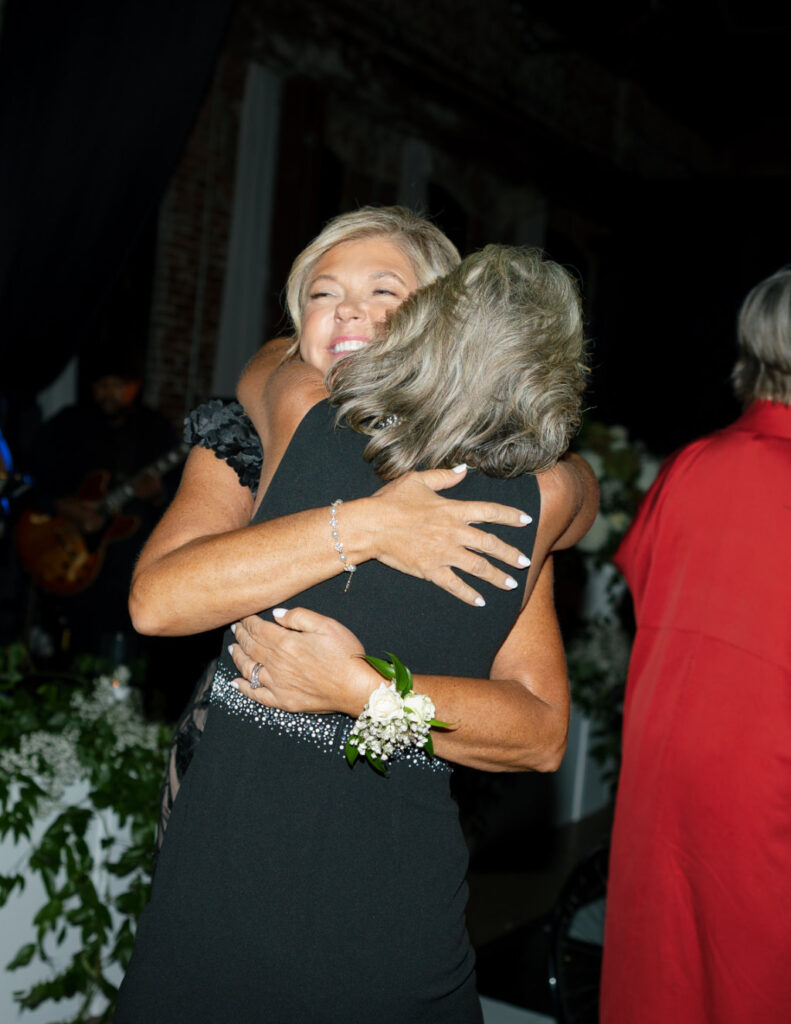 In-law family members hugging the bride joyfully during the reception.