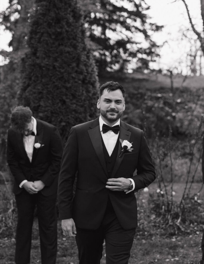 Groom adjusting his suit jacket before the ceremony.