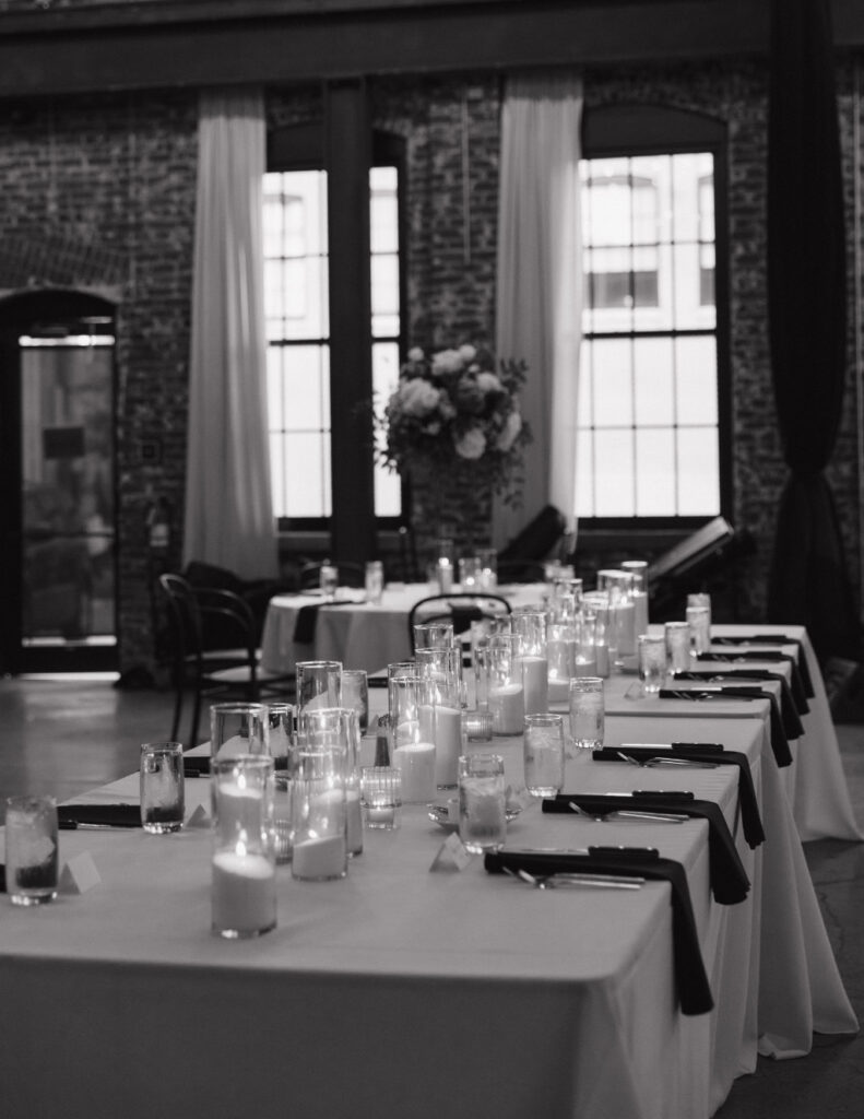 Elegant indoor tablescape featuring candles, greenery, and modern black-tie styling.