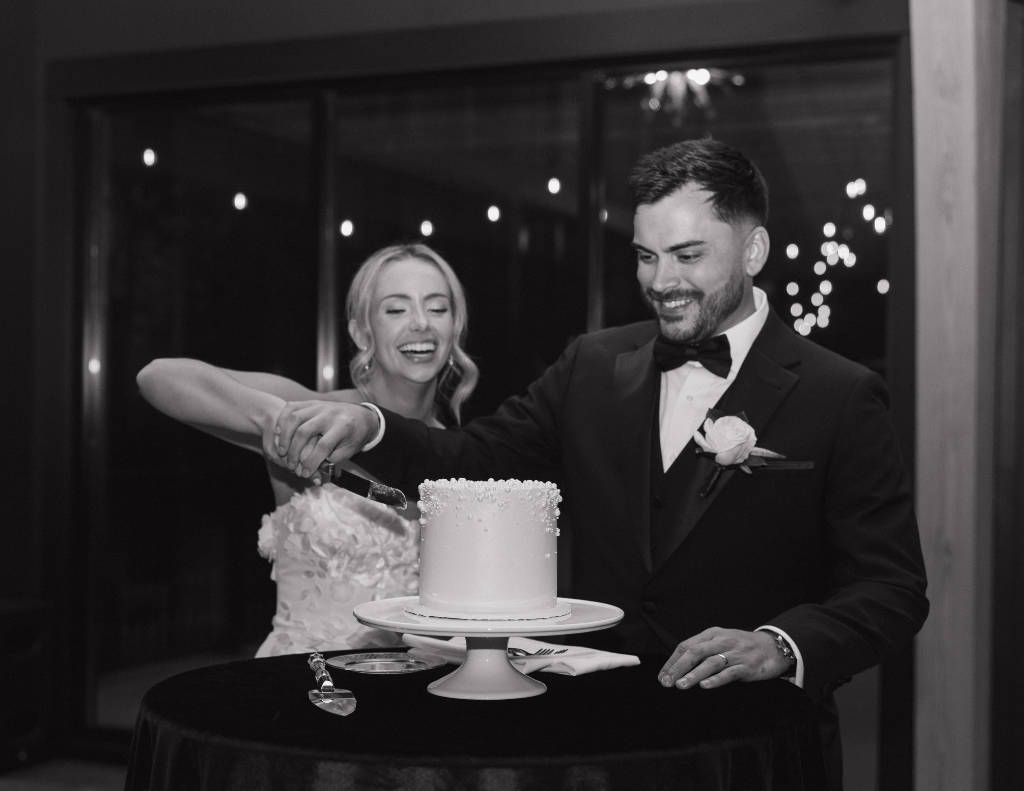 Reception setup with warm lighting and elegant décor during the cake cutting at The Everhart Gathering Place.