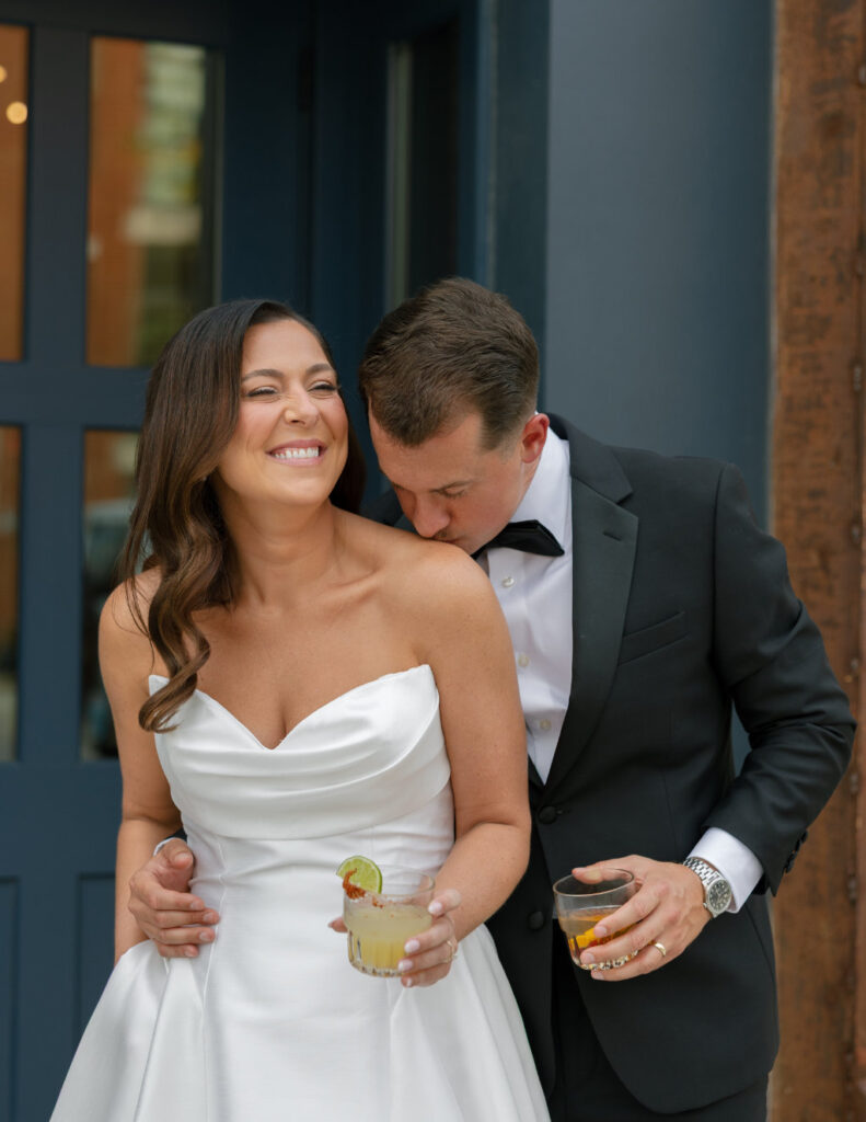 Husband kisses the shoulder of bride at The Ellis wedding venue in Ohio.