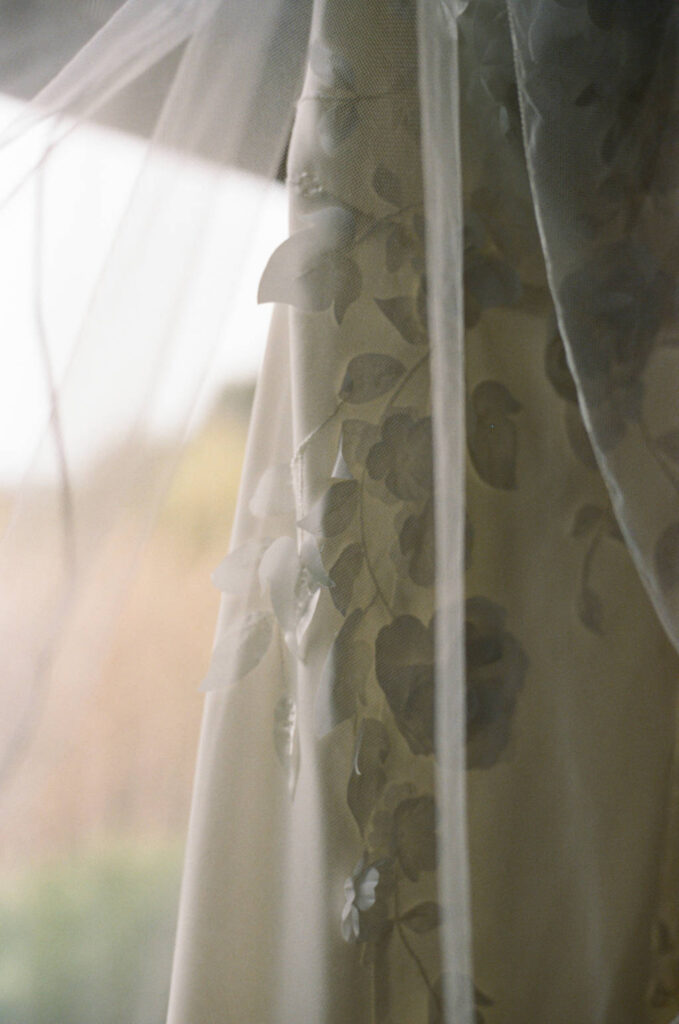 Close of a wedding dress showcasing floral details.