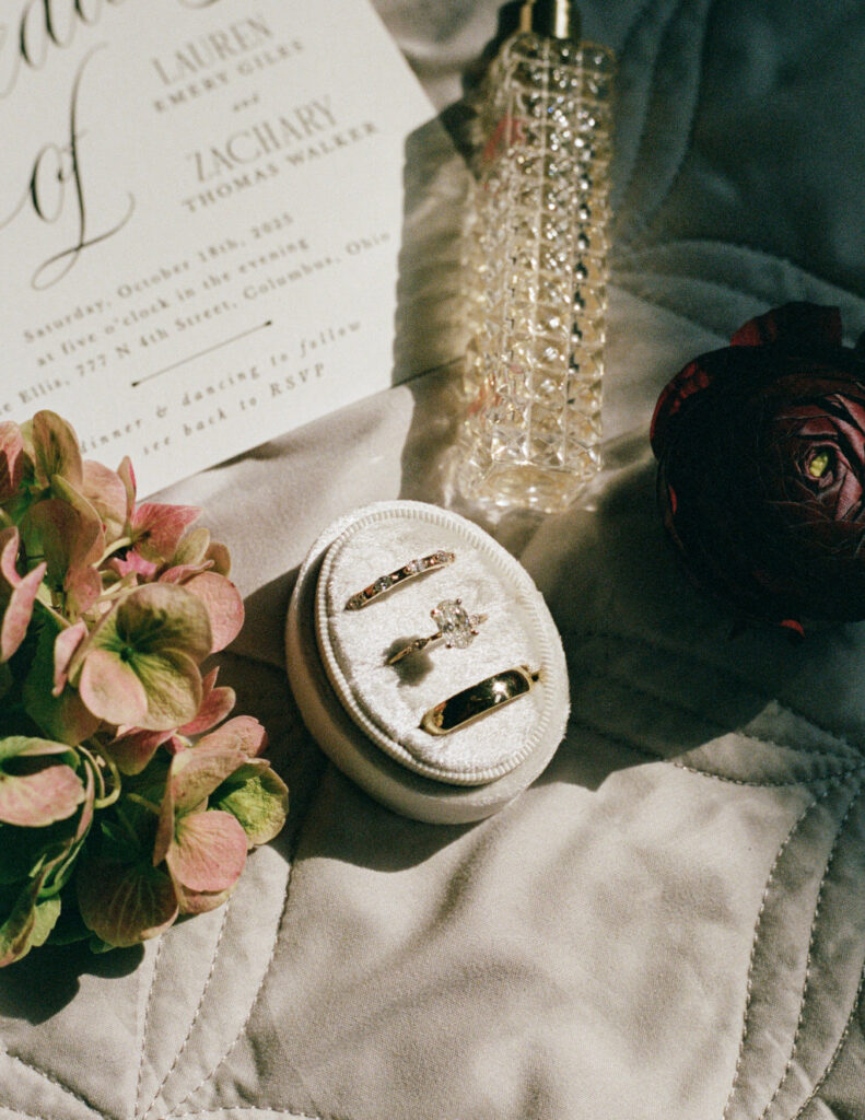 Close-up of wedding rings styled with florals and fabric.